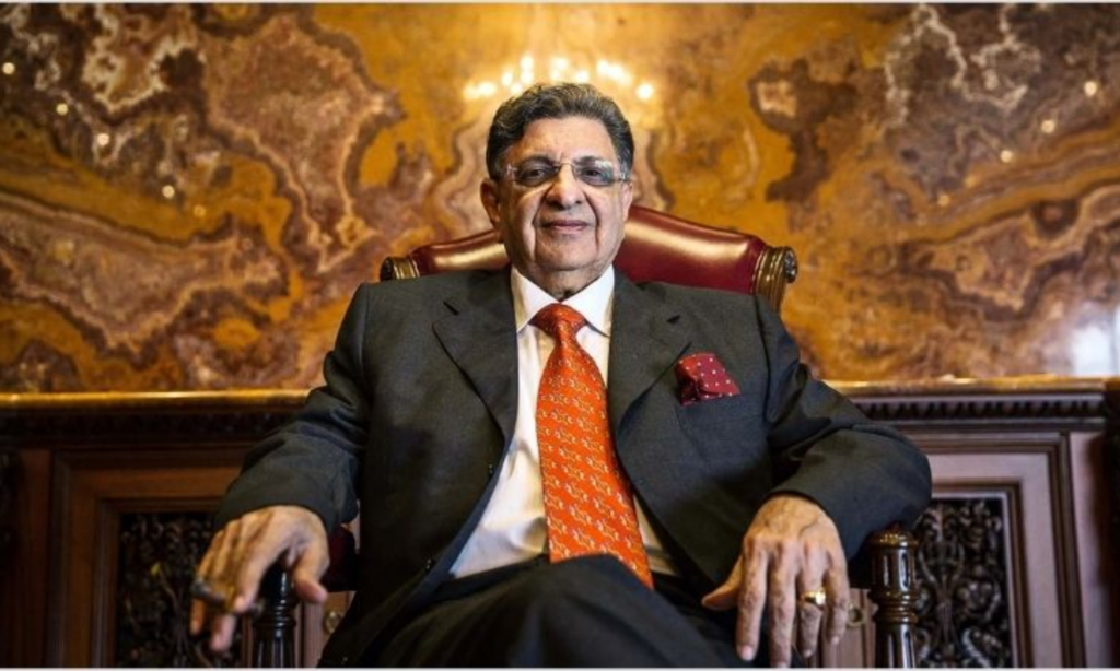 Cyrus Poonawalla sitting on a char smiling